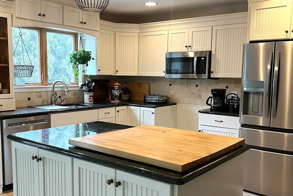 The same kitchen with cabinets sprayed white after refinishing