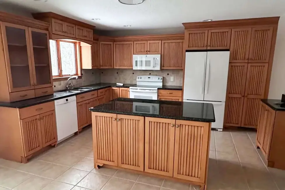 Kitchen with orange oak cabinets before refinishing