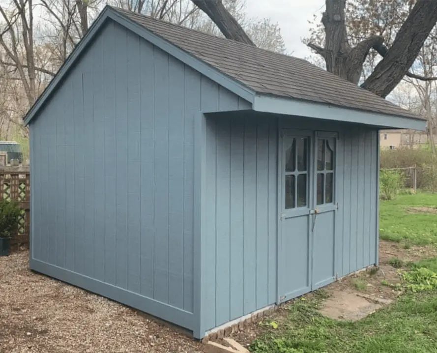 Garden shed repainted blue-grey under bare spring trees